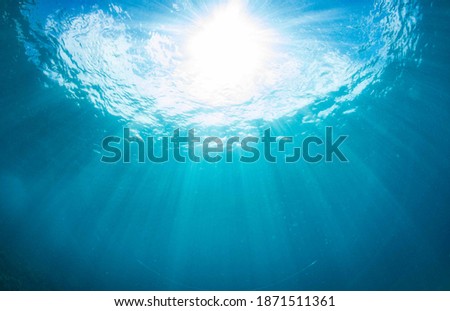 Sunburst through calm surface on the ocean
