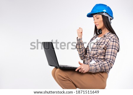 Serious woman architect communicates by video call on computer and shows a fist. White background.