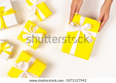 Demonstrating trendy colors of year 2021 - Gray and Yellow. Colorful gifts with ribbons