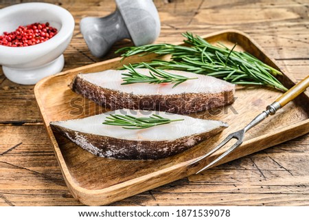 Raw halibut saltwater fish steak. wooden background. Top view
