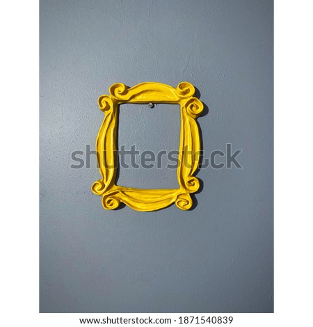 Yellow frame from the television show FRIENDS which was used around Monica's peep hole on the door. Purple wall. Picture frame. FRIENDS tv show frame