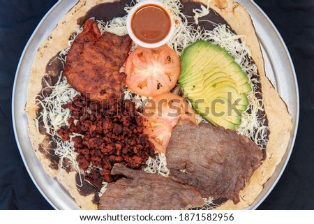 Overhead view of sampler taco plate to share with family including carne asada steak, hamburger, pollo chicken and avocado and tomato toppings.