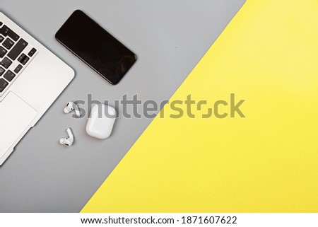 Desktop flat lay with laptop, mobile phone, wireless headphones. Colors of the year 2021: ultimate gray and illuminating. Trendy colors concept, mockup with copy space Royalty-Free Stock Photo #1871607622