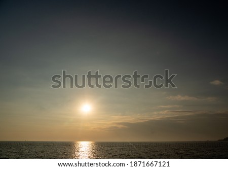 The front view overlooking the sea where the waves are quiet. Clouds that are visible to gray Where the sun is setting Golden shining In the evening That is twilight Suitable for taking pictures