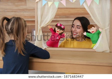 Mother performing puppet show for her daughter at home Royalty-Free Stock Photo #1871683447