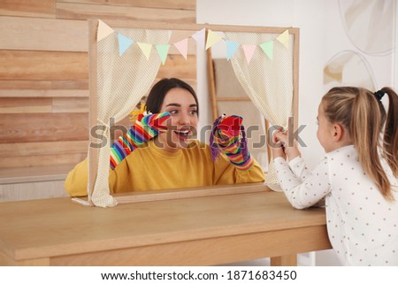 Mother performing puppet show for her daughter at home Royalty-Free Stock Photo #1871683450