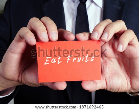 Eat Fruits  sign on the piece of paper.
