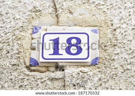 Number eighteen on a wall, detail of a number of information on a wall, even number