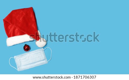 Santa Claus hat on a blue background. Mockup for design creation. Festive Christmas quarantine. For wallpaper, postcards and backgrounds.