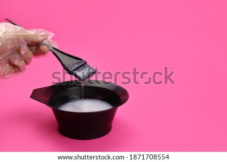 Hairdresser, stylist mixes hair dye in a plastic bowl Royalty-Free Stock Photo #1871708554