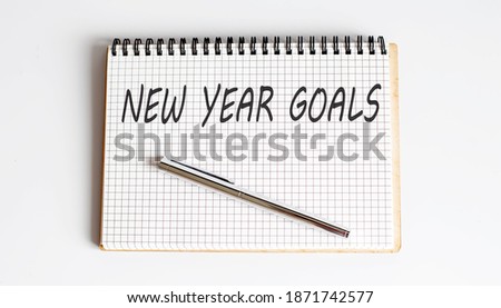 Notebook with pen and Notes about NEW YEAR GOALS , business concept