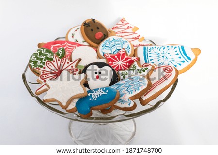 A beautiful selection of traditionally decorated, homemade gingerbread cookies for Christmas served on a glass bowl