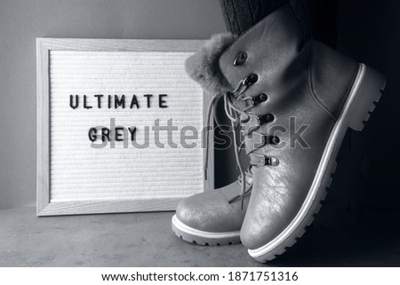 trendy ultimate grey fashionable boots with letter board demonstrating modern color of 2021