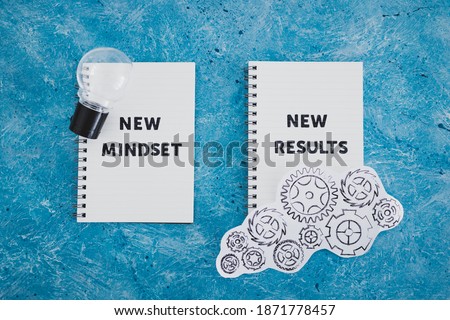 law of attraction conceptual image, notepad with New Mindset New Results text with light bulb and gearwheel mechanism Royalty-Free Stock Photo #1871778457