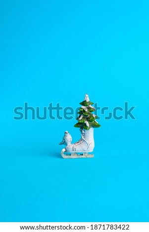 Christmas toy, ceramic model of skates and Christmas tree on a blue background
