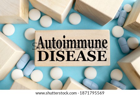 AUTOIMMUNE DISEASE. TEXT ON A WOODEN BAR on a blue background. Medical concept. Royalty-Free Stock Photo #1871795569