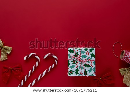Christmas composition. Gifts, presents wrapped ribbon, lights, candy canes decorations on red background. Winter, new year Flat lay, top view, copy space. Template mockup greeting card text design