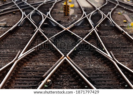 Railway tracks with switches and interchanges at main lines in Frankfurt Germany to various destinations. Symmetry and geometrical structures, lines and high contrast of rails and thresholds  gravel. Royalty-Free Stock Photo #1871797429