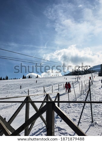 Beautiful natural landscape with mountains covered with snow. Picture of ski lift at sunny weather and blue sky. Active recreation in the mountains. Isolation concept during quarantine.