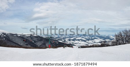 Beautiful natural landscape with mountains covered with snow. Landscape picture of ski resort and ski lift from top. Active recreation in the mountains. Isolation concept during quarantine.