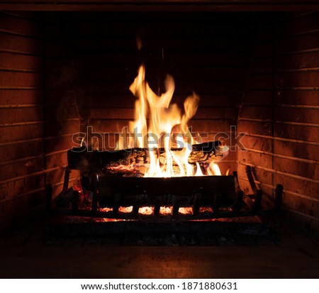 Fireplace, cozy warm fireside. Fire burning, logs flaming, firebricks background. Relaxation at home winter holiday christmas time