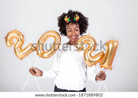 Happy young African American woman holding 2021 gold color balloons for celebrate merry Christmas and happy new year on white background, celebration and decoration for holiday event concept Royalty-Free Stock Photo #1871889802