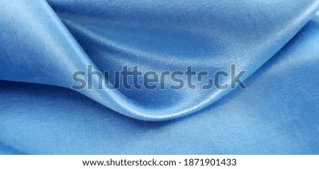 Blue satin fabric in folds (texture).