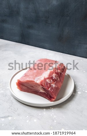 Raw  meat with rosemary, sage and garlic on trendy gray  grey background. Preparing ham beef lamb for family lunch or dinner. 