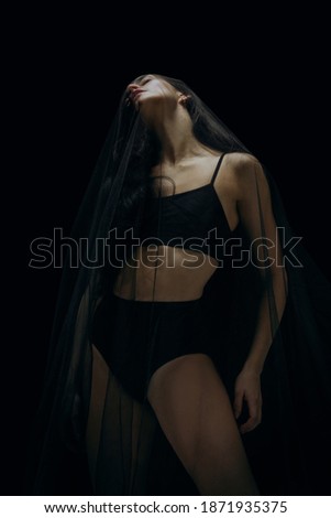 Dreams. Graceful classic female ballet dancer isolated on black studio background. Woman in minimalistic black cloth looks graceful, inspired. The grace, artist, movement, action and motion concept.