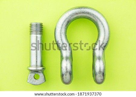 Steel metal rigging shackle wih screw pin anchor on green background. Professional rigging gear.