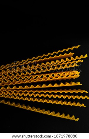 Various uncooked pasta on dark black background. Top view. Raw pasta with ingredients for cooking. Food concept. Different  types of Italian pasta on black table. Top view. Copy space.