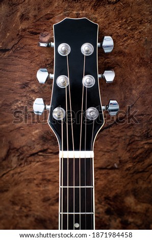 Acoustic Guitar Headstock on wooden background Royalty-Free Stock Photo #1871984458