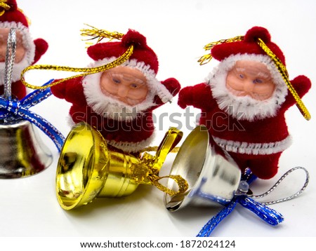 three funny santa claus toys with christmas bells on white background. In focus and out of focus