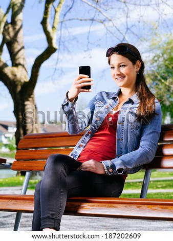 Photo of a beautiful young woman using a smartphone to take photos.
