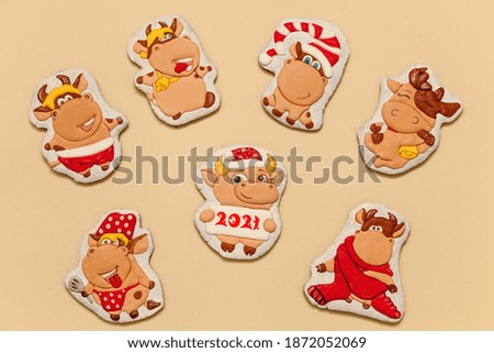 Gingerbread bulls as a symbol of 2021 on a beige background. Christmas, Happy New Year 2021. Magic holiday card