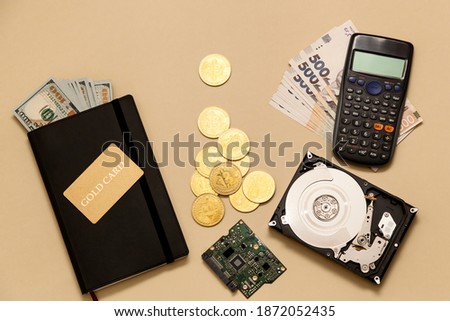 Business concept items on the table gold bitcoins, dollars, diary, gold card, hard disk on a beige background. Bitcoins are a digital currency, the global market for trade and exchange of money.