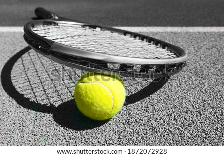 Close up of tennis racquet and ball on the clay tennis court
