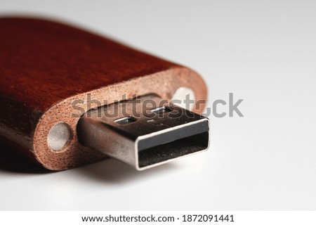 Close-up of a USB flash drive in a wooden case. Close-up on gray gradient background