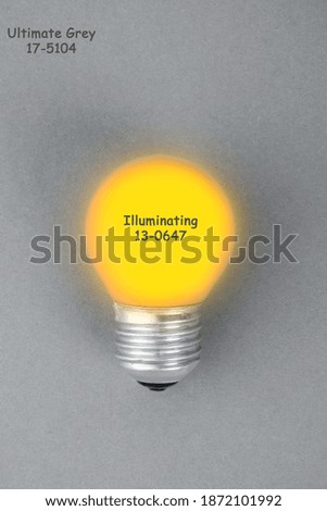 Illuminating Yellow lamp on trendy ultimate grey background. Creative idea concept. Minimalism. Top view. Flat lay. Lighting, electricity,  trendy colors of 20