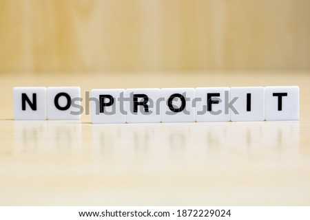 A row of small white plastic tiles, containing the letters forming the word no profit, to represents the business with profit and those without profit.
