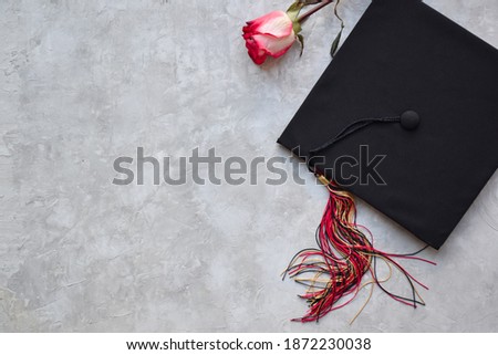 Graduation cap on grey background Royalty-Free Stock Photo #1872230038