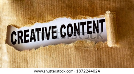 Text Creative content is written on torn brown paper.