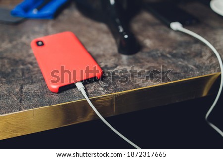 Charging Smartphone With Grey Portable External Battery powerbank on Wooden Table .