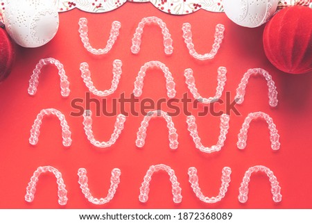 Invisible and transparent dental aligners on a wooden table with christmas and winter decoration