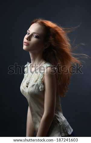 beautiful red-haired girl in the dark blue background
