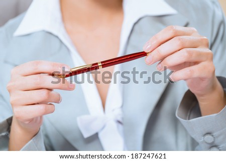 close-up of hands of a business woman, holding a red pen