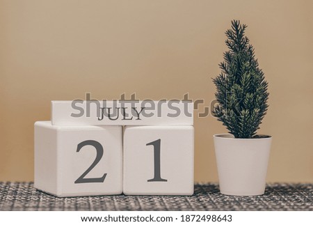 Desk calendar for use in different ideas. Summer month - July and the number on the cubes 21. Calendar of holidays on a beige solid background.