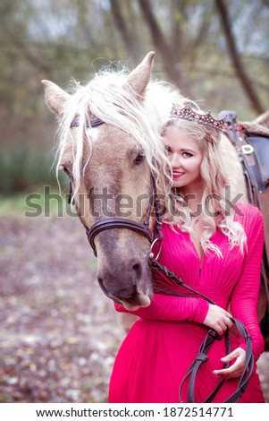 Beautiful woman in crown, blonde with horse. Princess in fairy tale. Fantasy autumn