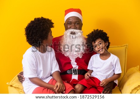 Christmas in family. Father dressed as Santa Claus together with Afro children