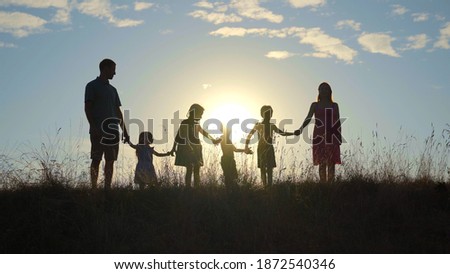 Happy large family at sunset with a dog.